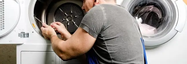 Dryer repair technician fixing a clothes dryer drum in Charlotte, NC