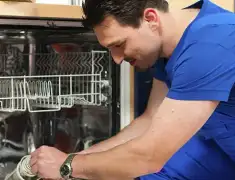 Dishwasher repair technician inspecting and servicing an open dishwasher in Charlotte, NC