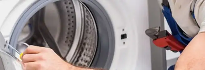 Appliance technician repairing a clothes dryer drum and internal parts in Charlotte, NC