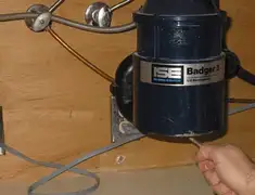 Garbage disposal repair technician tightening the mounting ring under a sink in Charlotte, NC