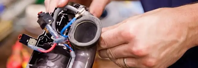 Vacuum repair technician reconnecting wiring and components in Charlotte, NC