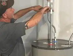 Water heater repair technician tightening supply line connections in Charlotte, NC